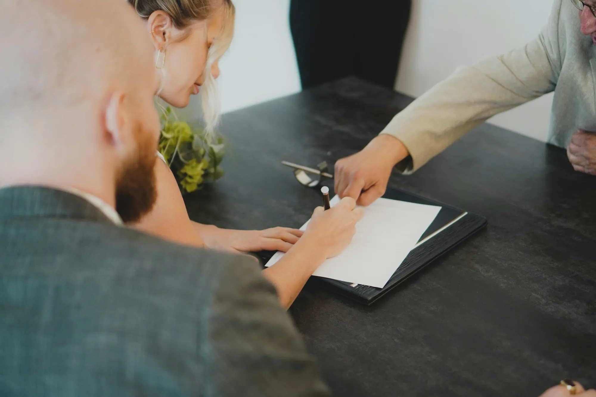 Two people signing a written job scope at a desk