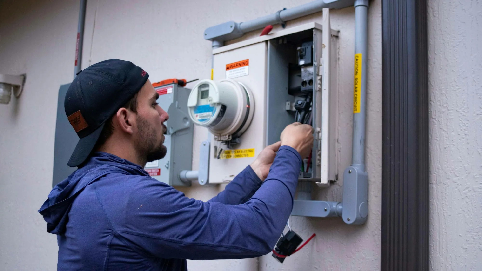 Electrician working at a residential meter and service panel