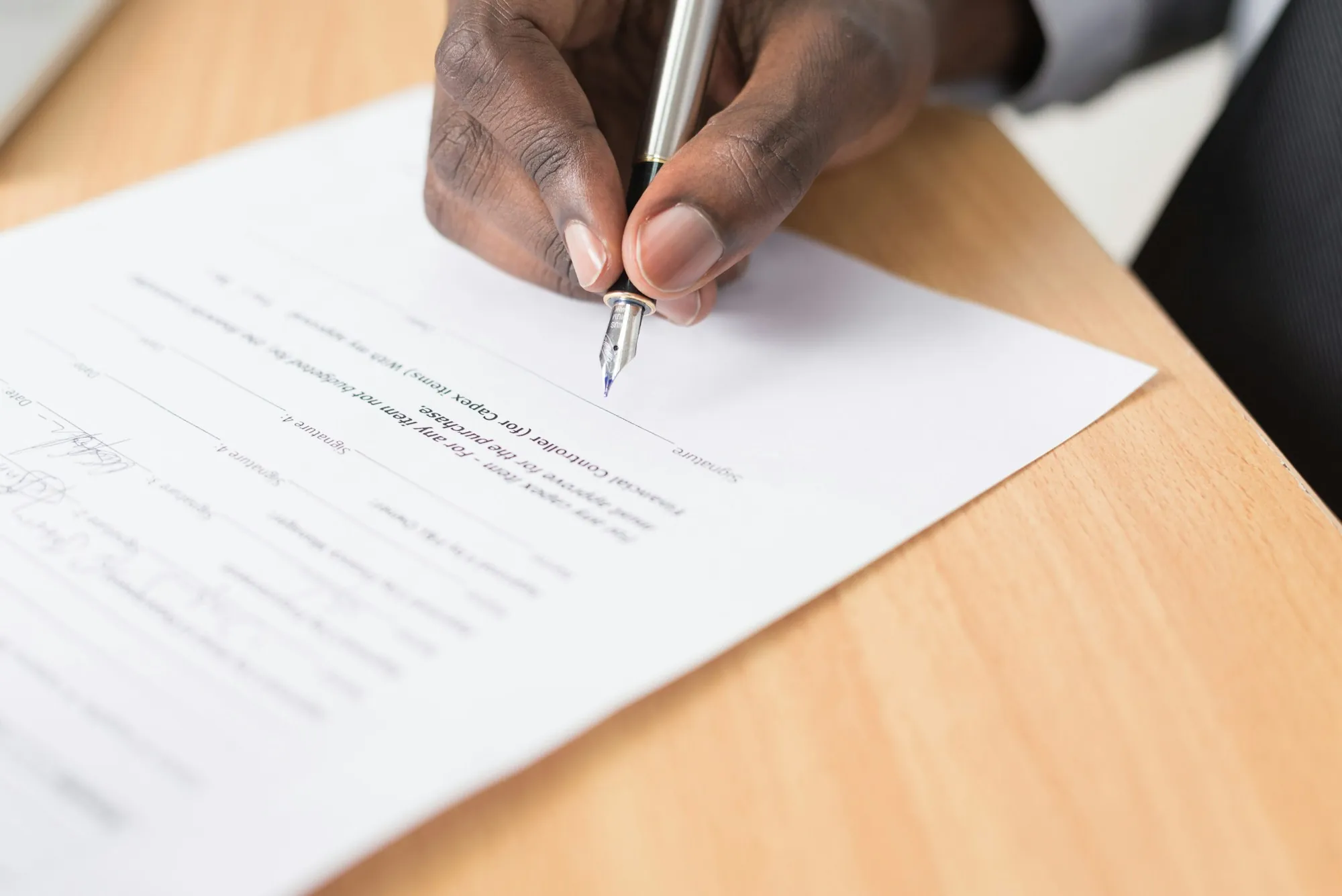 A person writing on a sheet of white paper